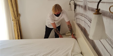 Powiększ grafikę: wizyta monitorująca - Bartek podczas serwisu sprzątającego w dziale służby pięter - ścielenie łóżka - w hotelu Sovrana