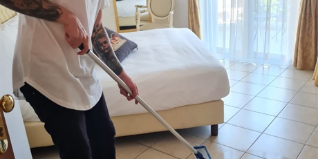 Powiększ grafikę: wizyta monitorująca - Bartek podczas serwisu sprzątającego w dziale służby pięter - mopowanie podłogi w pokoju  hotelowym - w hotelu Sovrana
