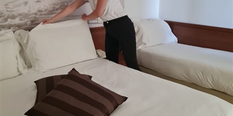 Powiększ grafikę: wizyta monitorująca - Klara podczas serwisu sprzątającego w dziale służby pięter - ścielenie łóżka -w hotelu Sovrana
