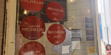 Powiększ grafikę: wizyta monitorująca koordynatorki projektu - wejście do restauracji Osteria, widoczne rekomendacje przewodnika Michelin