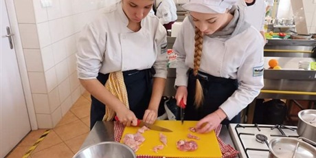 Powiększ grafikę: Oliwia i Ania podczas pracy na stanowisku w trakcie warsztatów kuchni hiszpańskiej 